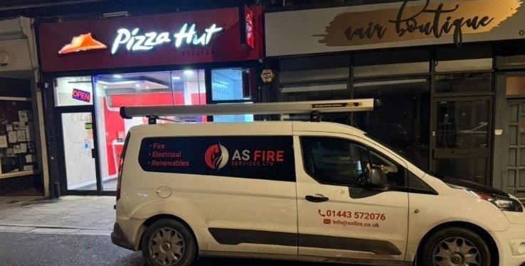 AS Fire Services Ltd branded engineer van parked outside a commercial premises in South Wales at night.